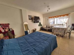 une chambre avec un lit bleu et un salon dans l'établissement Departamento monoambiente Plaza Mitre, à Mar del Plata