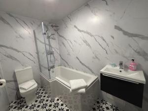 a bathroom with a shower and a toilet and a sink at East Halton Hotel in East Halton