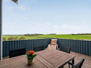 a wooden table and chairs on a deck at Holiday Home Marne - 500m from the sea by Interhome in Løkken +29 photos