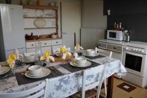 a kitchen with a table with plates and dishes on it at Maison Plain-Pied in Saint-Quentin-sur-Charente