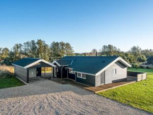a house with a metal roof on a gravel driveway at Holiday Home Oskarvine - 900m from the sea by Interhome in Løkken