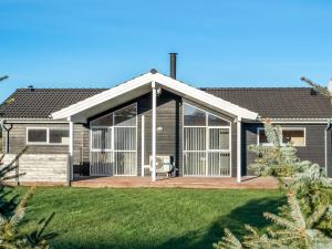 a house with a large screened in porch at Holiday Home Oskarvine - 900m from the sea by Interhome in Løkken