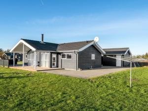 a house with a large deck in a yard at Holiday Home Oskarvine - 900m from the sea by Interhome in Løkken