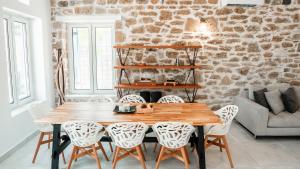 a dining room with a wooden table and chairs at Bluevera luxury villa in Gialtra +10 photos