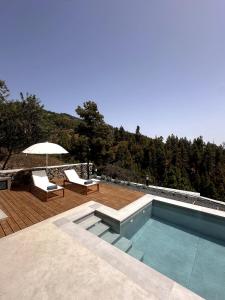 a swimming pool with two chairs and an umbrella at Casa Arriettas in Tijarafe