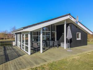 a large screened in deck with chairs and an umbrella at Holiday Home Nynke - 600m from the sea by Interhome in Løkken