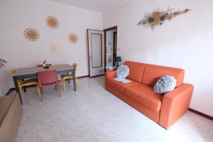 a living room with an orange couch and a table at Estar Sogni by PortofinoVacanze in Rapallo