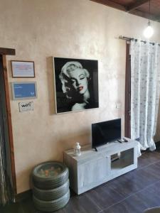 Una sala de estar con un televisor en la pared. en Casa Nina, en Siracusa