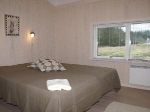 a bedroom with a bed with a pillow and a window at Holiday Home Asol - 650m from the sea by Interhome in Løkken