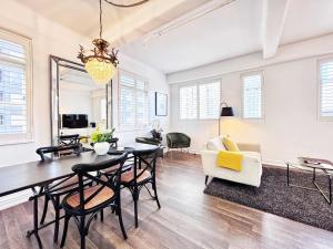 a dining room and living room with a table and chairs at Central Queen St Stylish Penthouse 1BR Gem in Auckland