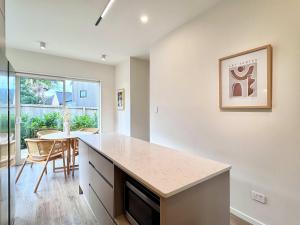 una cucina con un bancone e un tavolo con sedie di Family Oasis 3BR vs Backyard Near Beach in Torbay ad Auckland