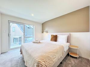 a bedroom with a large bed and a large window at Family Oasis 3BR vs Backyard Near Beach in Torbay in Auckland