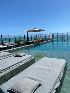 uma piscina com duas camas na água em Flat completo a 50m do mar do Bessa - até 4 pessoas em João Pessoa
