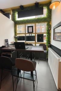 a room with a table and chairs with a green wall at Hôtel Le Paris Brest in Lens