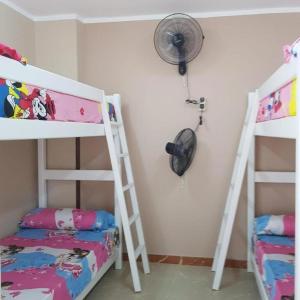 a bedroom with two bunk beds and a fan at Sweet Home Hostel - ممنوع للبنات فى الوقت الحالى in Hurghada