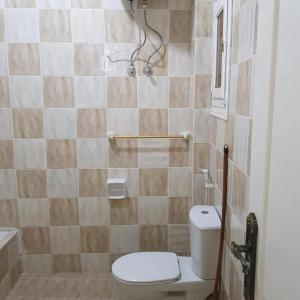 a small bathroom with a toilet and a shower at Sweet Home Hostel - ممنوع للبنات فى الوقت الحالى in Hurghada +12 photos