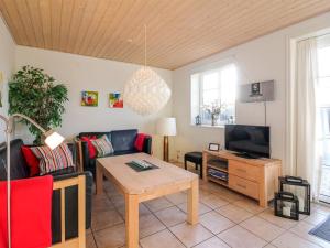 a living room with a couch and a tv at Apartment Frænde - 600m from the sea by Interhome in Løkken
