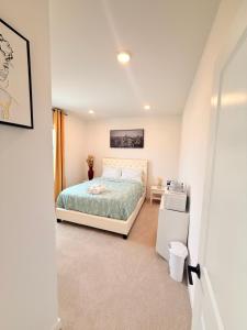 a small bedroom with a bed and a refrigerator at Cozy Retreat, Room 2, Near Mt Rainier, Seattle, National parks in Bonney Lake
