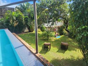 un cortile con piscina e un cortile con sedie di Casa Leque - Praia da Pipa - Centro a Pipa