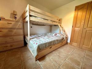 ein Schlafzimmer mit einem Etagenbett und einer Kommode in der Unterkunft 3 pièces, 6 pers, animaux admis, parking, vue sur piscine - FR-1-572-5 in Arâches-la-Frasse