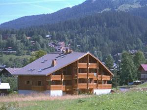 ein Haus mit einem Gamerleitdach auf einem Hügel in der Unterkunft Duplex lumineux 3 pièces, 7 pers, 3 balcons, proche pistes et commerces, parking, ski bus - FR-1-572-72 in Arâches-la-Frasse