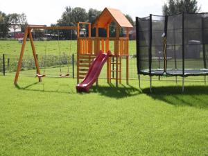 einen Spielplatz mit zwei Schaukeln und einer Rutsche in der Unterkunft Haus Hermann in Mederns