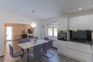 a kitchen and dining room with a table and chairs at Villa Velaria with private pool in Donja Glavina