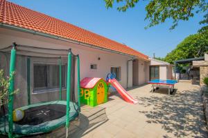 a backyard with a slide and a playground at Villa Velaria with private pool in Donja Glavina