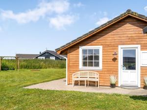 a wooden house with a bench in front of it at Holiday Home Anya - 650m from the sea by Interhome in Løkken