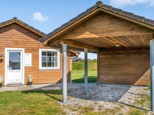 a wooden house with a wooden garage at Holiday Home Anya - 650m from the sea by Interhome in Løkken +18 photos