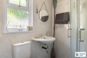 a bathroom with a toilet and a sink and a mirror at Lakeside Lodge in Caernarfon +54 photos