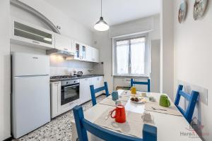 a kitchen with a table and chairs and a refrigerator at Strategic Center Location - Train - Cruise & Beach in Savona