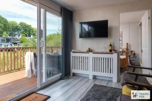 a living room with a sliding glass door with a television at Lakeside Lodge in Caernarfon