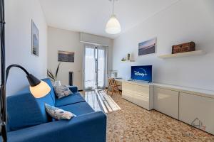a living room with a blue couch and a desk at Strategic Center Location - Train - Cruise & Beach in Savona