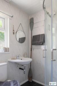 a white bathroom with a sink and a shower at Lakeside Lodge in Caernarfon