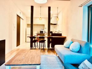 Ainan波止場の海まで徒歩30秒の貸切宿 "ギョグンミニ" "Gyogun Mini"的带蓝色沙发的客厅和厨房