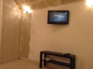 um quarto com uma televisão na parede com uma mesa em Sea Home 2 em Monopoli