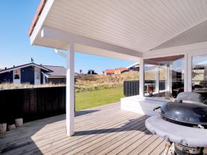 einen Pavillon mit einem Grill auf einer Holzterrasse in der Unterkunft Holiday Home Nedelko - 250m from the sea by Interhome in Blokhus