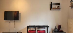 a living room with two chairs and a flat screen tv at Schöne gemütliche Wohnung in Meerbusch