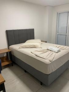 a bed in a white room with a bedskirtspectspectssenalsenalsenalsenal at Hotel Califórnia Cruz Alta in Cruz Alta