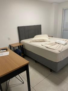a bedroom with a bed and a table and a desk at Hotel Califórnia Cruz Alta in Cruz Alta +6 photos