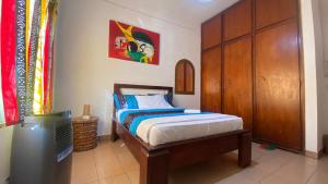 a bedroom with a bed and a wooden cabinet at FIIAA in Yaoundé