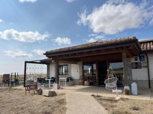 a building with a porch with a table and chairs at Fuente Sidres  +12 photos