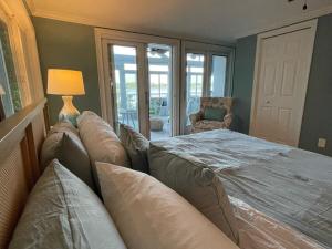 a bedroom with a bed with a couch and a lamp at Palms in Paradise 2 Docks & Steps into Lake Murray in Chapin