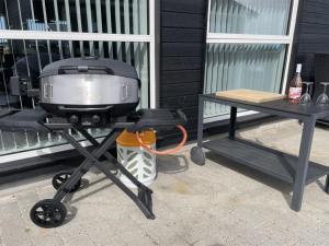 a grill on a picnic table next to a table at Holiday Home Dwerg - 1-5km from the sea by Interhome in Løkken