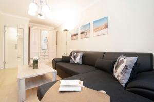 a living room with a couch and a table at Tannenburg Wohnung 205 in Grömitz