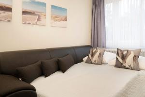 a couch with pillows on it in a room at Tannenburg Wohnung 205 in Grömitz