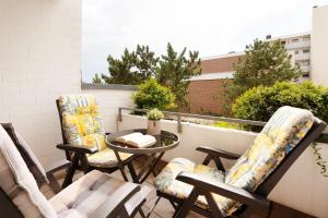 a patio with chairs and a table on a balcony at Tannenburg Wohnung 205 in Grömitz