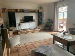a living room with a tv and a couch and a table at Ferienwohnung Bergblick in Winterberg