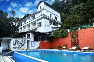 a building with a swimming pool in front of a building at Tree Blanche Resort Munnar in Anachal